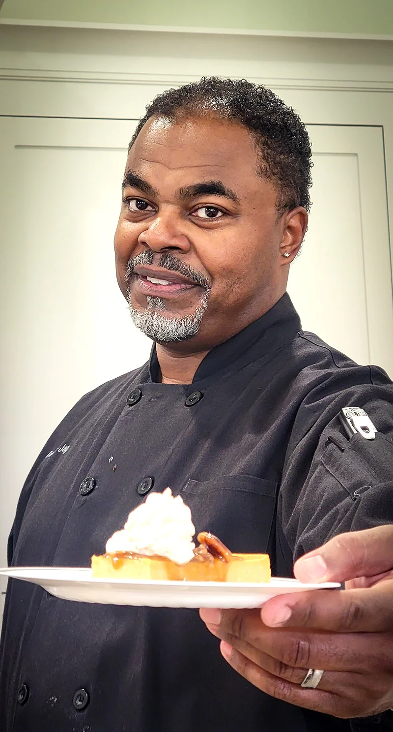 Portrait of Chef TJay presenting a plated dessert